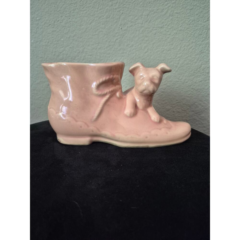 This is a vintage Shawnee Pottery puppy on a lady boot planter in pink